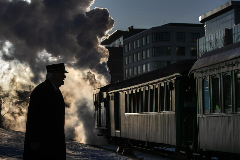 Steam billows from a locomotive as The Polar Express departs for the "North Pole" under the watch of conductor Jerry Angier, Friday, Dec. 20, 2019, in Portland, Maine. The annual holiday journey is staffed mostly by volunteers and is the largest annual fundraiser for the Maine Narrow Gauge Railroad Museum. (AP Photo/Robert F. Bukaty)
