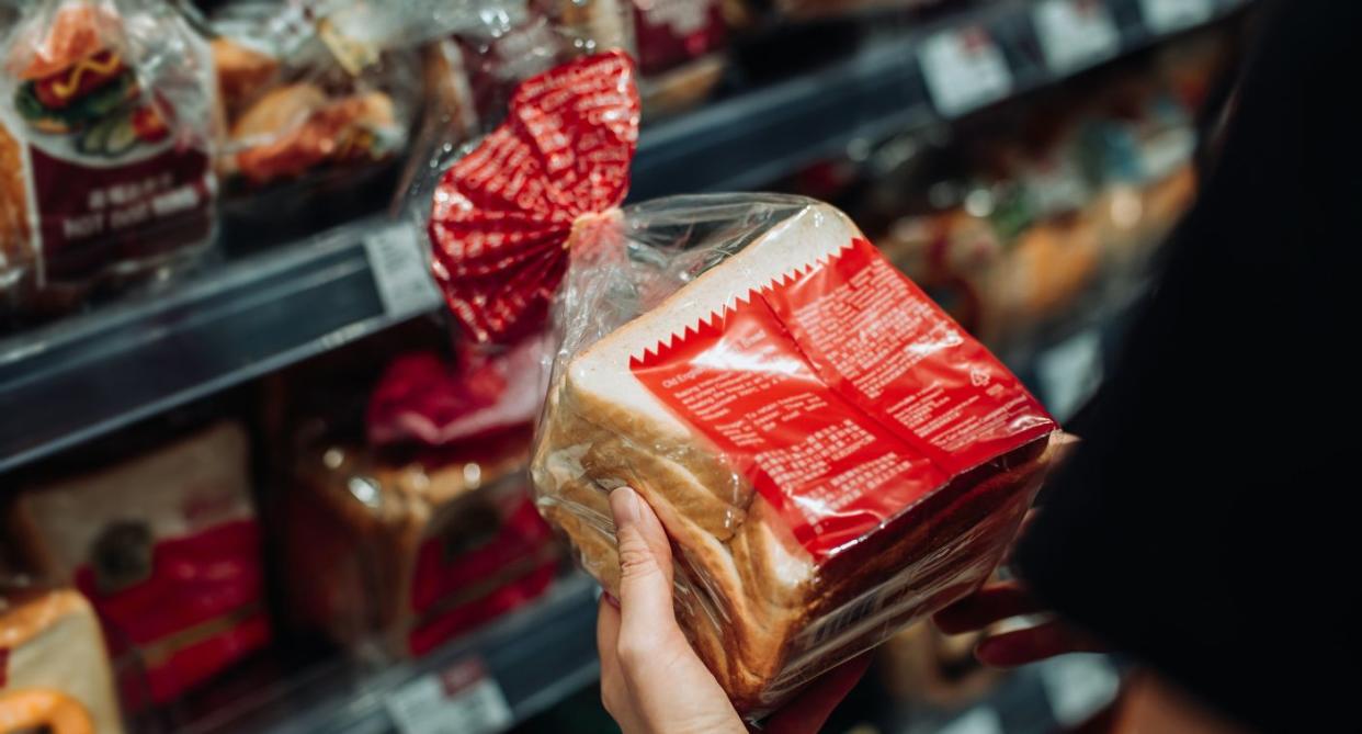 Holding bread looking at gluten-free label. (Getty Images)