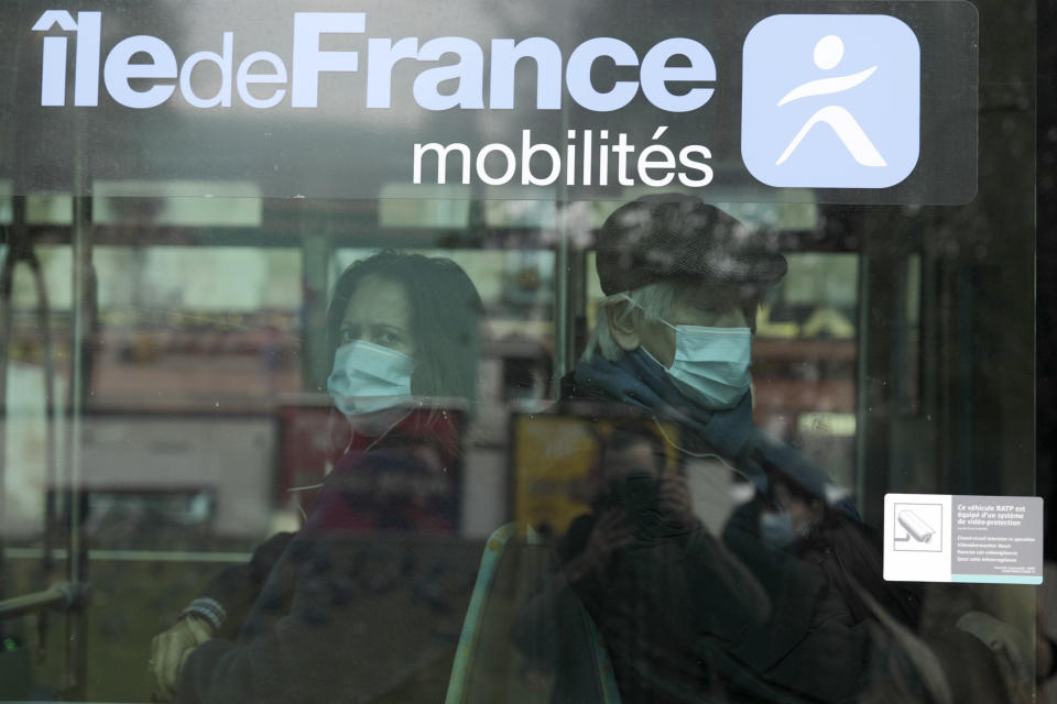 Masked commuters sit in a bus Thursday, Oct. 15, 2020 in Paris. French President Emmanuel Macron has announced that millions of French citizens in several regions around the country, including in Paris, will have to respect a 9pm curfew from this Saturday until Dec. 1. It's a new measure aimed at curbing the resurgent coronavirus amid second wave. The measures will require citizens in certain regions where the coronavirus is circulating to be at home after 9pm. (AP Photo/Lewis Joly)