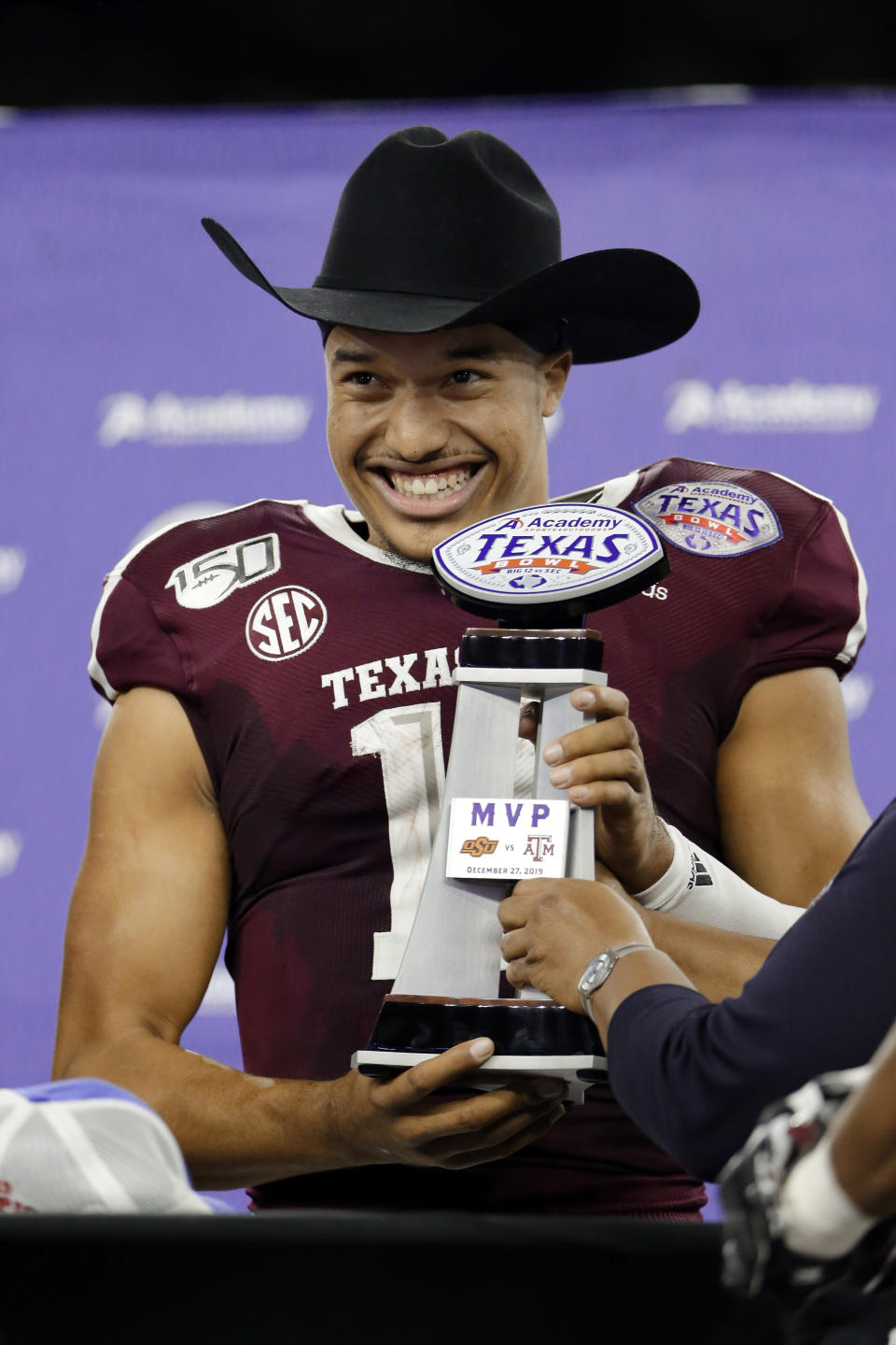 Texas A&M quarterback Kellen Mond (11) dons the traditional cowboy hat and holds the MVP trophy after the team's 24-21 win over Oklahoma State in the Texas Bowl NCAA college football game Friday, Dec. 27, 2019, in Houston. (AP Photo/Michael Wyke)