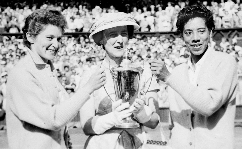 FILE - In this July 7, 1956, file photo, the Duchess of Kent, center, presents the trophy for the Ladies' Doubles title to Angela Buxton, left, and Althea Gibson, right, following their victory at Wimbledon, England. Gibson won an amazing 11 Grand Slam titles in three years from 1956-58, including the French Open, Wimbledon and U.S. Open. On Monday, Aug. 26, 2019, the USTA will unveil a statue in her honor at the U.S. Open. (AP Photo/File)