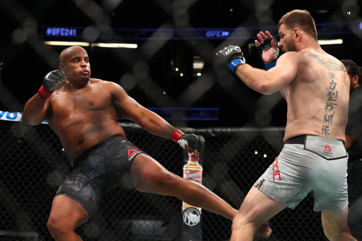 ANAHEIM, CALIFORNIA - AUGUST 17:  Daniel Cormier kicks Stipe Miocic in the first round during their UFC Heavyweight Title Bout at UFC 241 at Honda Center on August 17, 2019 in Anaheim, California. (Photo by Joe Scarnici/Getty Images)