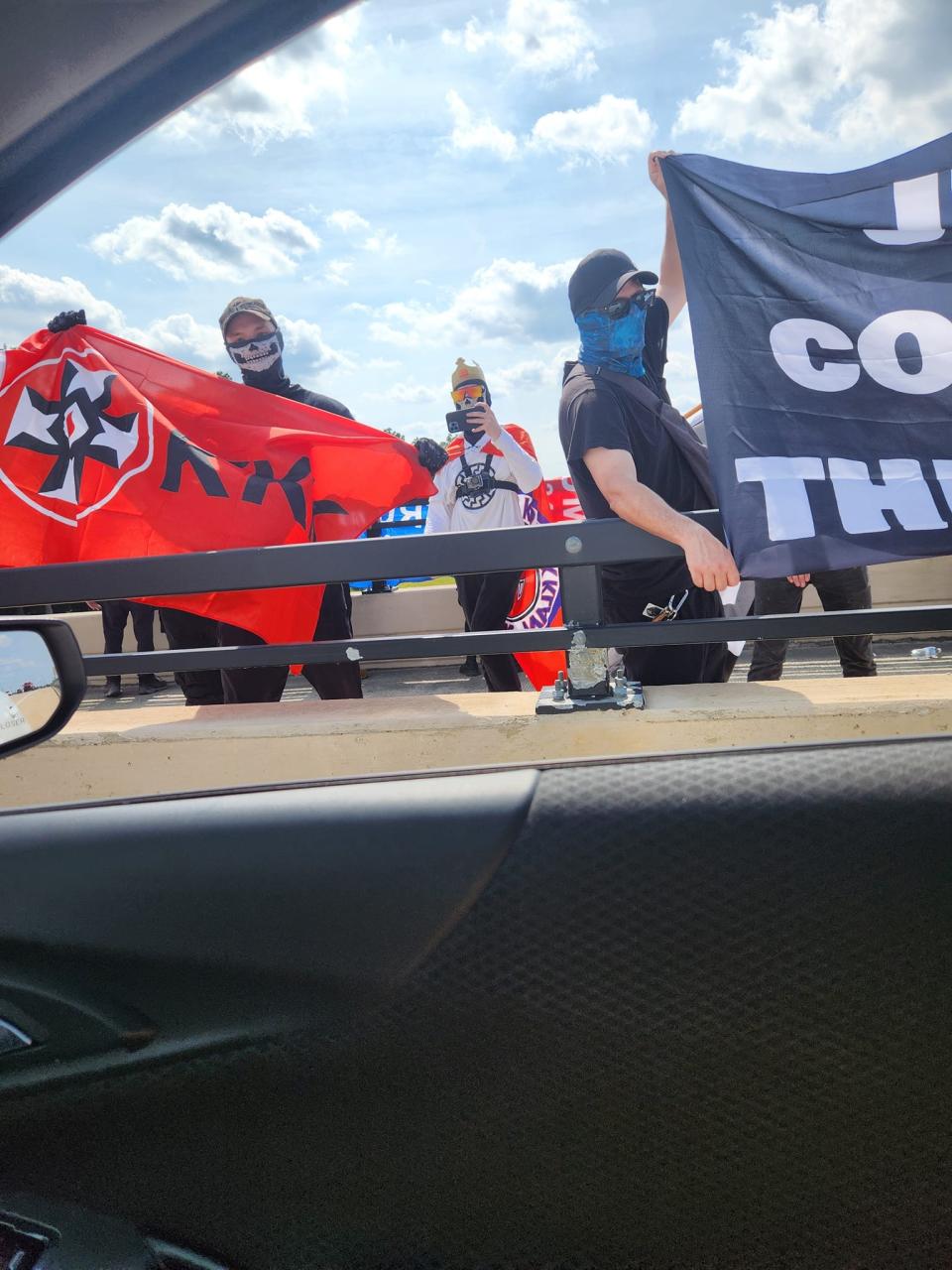 A demonstration Saturday, July 20, saw participants waving flags with antisemitic and white supremacist messaging, alongside a Trump flag, in Howell.