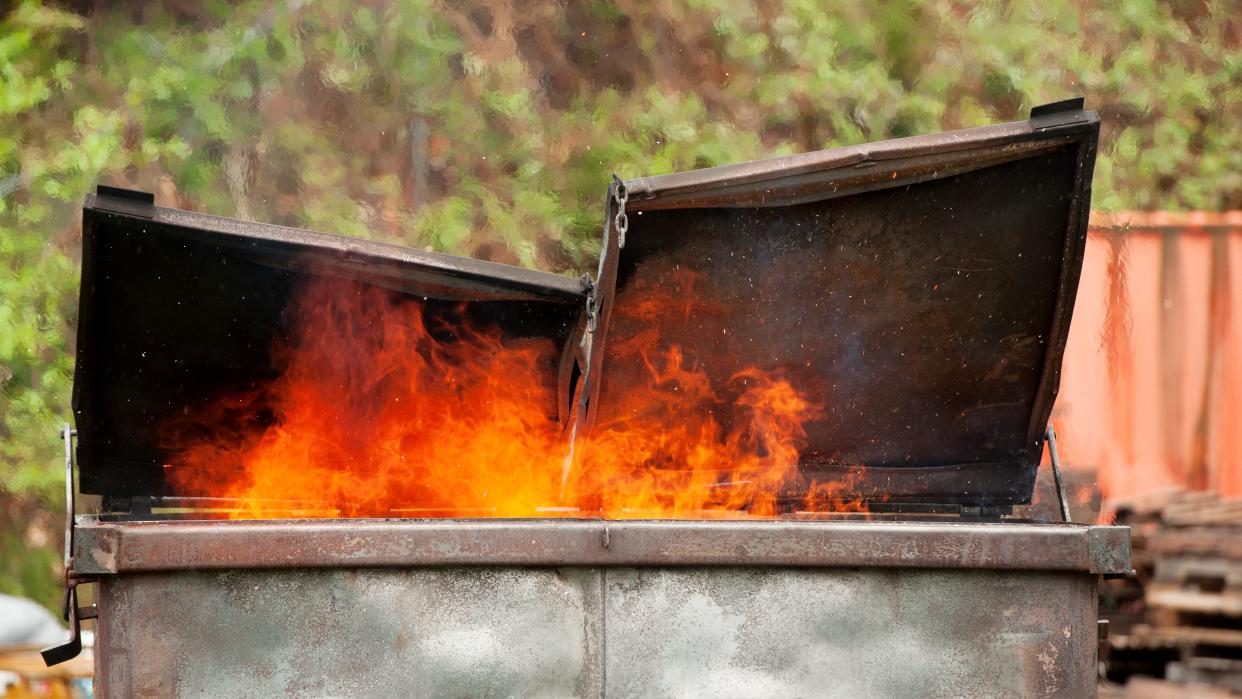  A photograph of a burning dumpster. 