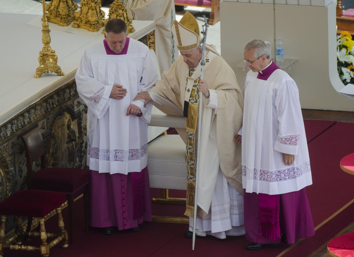 Pope Francis is helped walking as he celebrates the canonization mass for ten new saints in St. Peter's Square at The Vatican, Sunday, May 15, 2022. 