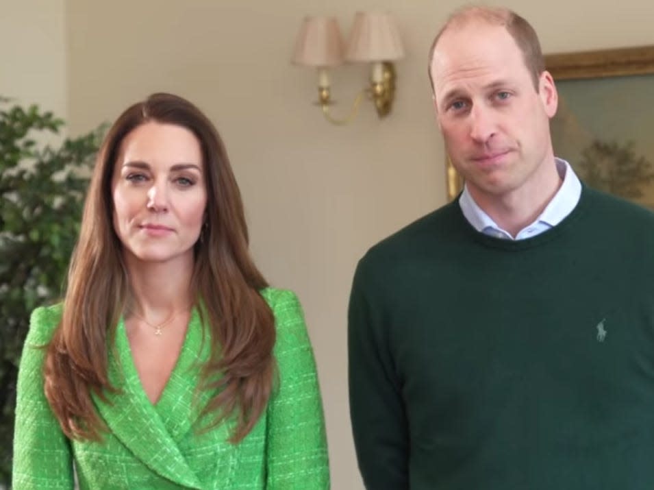 Kate Middleton wears a green blazer. She stands next to Prince William.