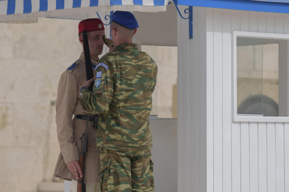 An army officer wipes the face of a member of the presidential guard, at the tomb of the Unknown Soldier, central Athens, on Thursday June 13, 2024. Temperatures are expected to exceed 40 C (104 F) on Thursday in much of central and southern Greece, including greater Athens, the Cyclades and Crete. The ancient Acropolis site was closed for second day to the public for five hours due to a heat wave. (AP Photo/Petros Giannakouris)