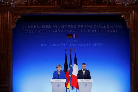 French President Emmanuel Macron and German Chancellor Angela Merkel attend a news conference following a Franco-German joint cabinet meeting at the Elysee Palace in Paris, France, July 13, 2017. REUTERS/Stephane Mahe