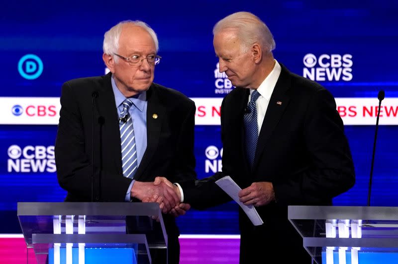 FILE PHOTO: Democratic 2020 U.S. presidential candidates Senator Bernie Sanders shakes hands with former Vice President Joe Biden after the tenth Democratic 2020 presidential debate at the Gaillard Center in Charleston