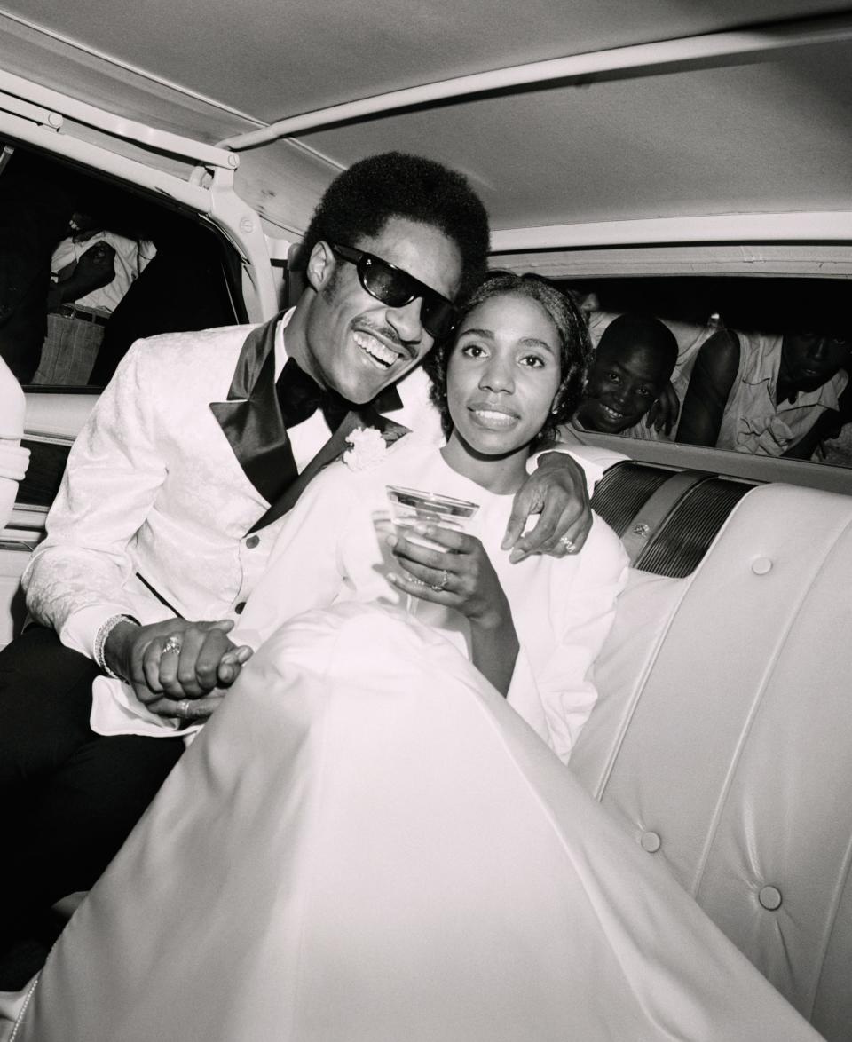 Stevie Wonder embraces his bride, Syreeta Wright, as they pose in their car.