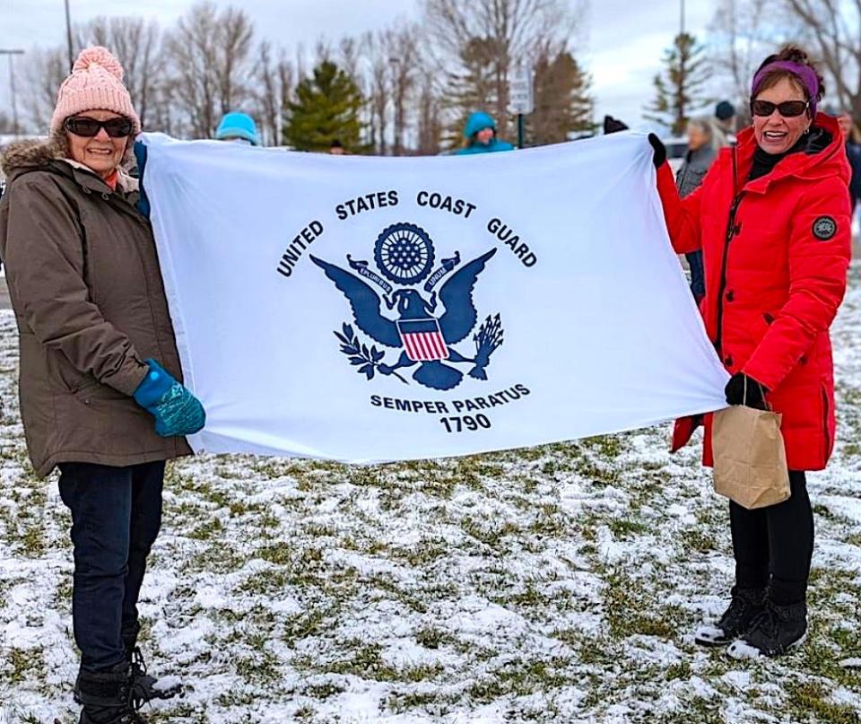 Mali Thomas and Sherry Nelson (right) were among those who waved off the Christmas Tree Ship in Cheboygan on Saturday. The U.S. Coast Guard Cutter Mackinaw is delivering Christmas trees and cards to Chicago.