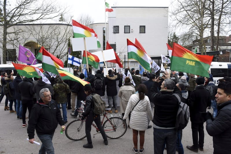 People attend a protest to support the demonstrations in Iran against the rise in gasoline prices outside the Embassy of Iran in Helsinki