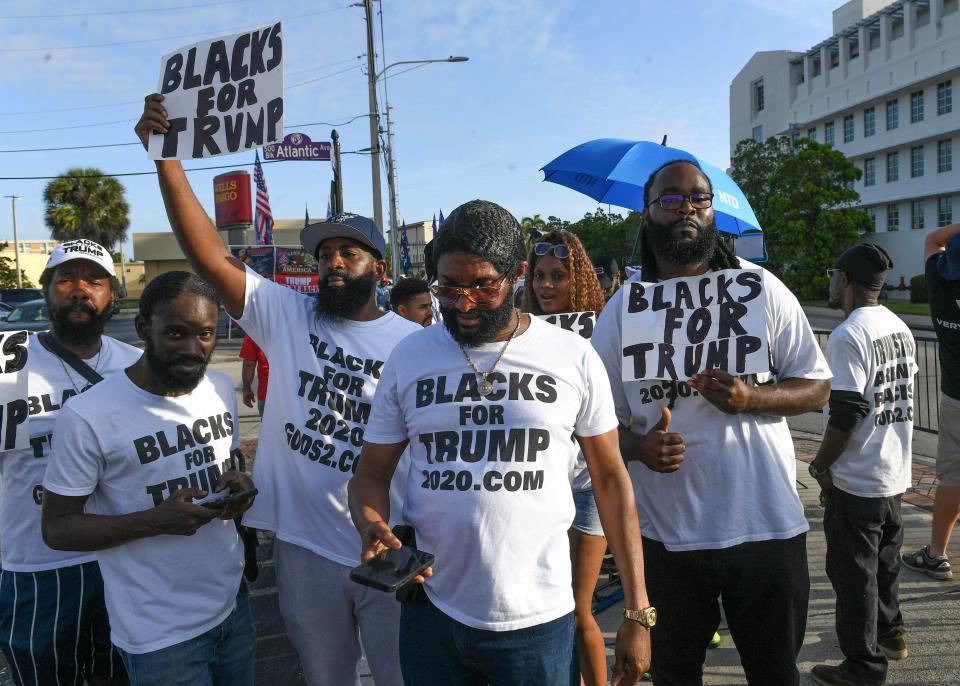 Men wearing "Blacks for Trump" shirts walk through the crowd of supporters waiting outside the Alto Lee Adams Sr. U.S. Courthouse for former President Donald Trump to arrive on March 14 for a hearing into his classified documents case in Fort Pierce, Florida.