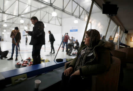 A refugee from Afghanistan looks out as she watches her family learn to curl at the Royal Canadian Curling Club during an event put on by the "Together Project", in Toronto, March 15, 2017. REUTERS/Mark Blinch