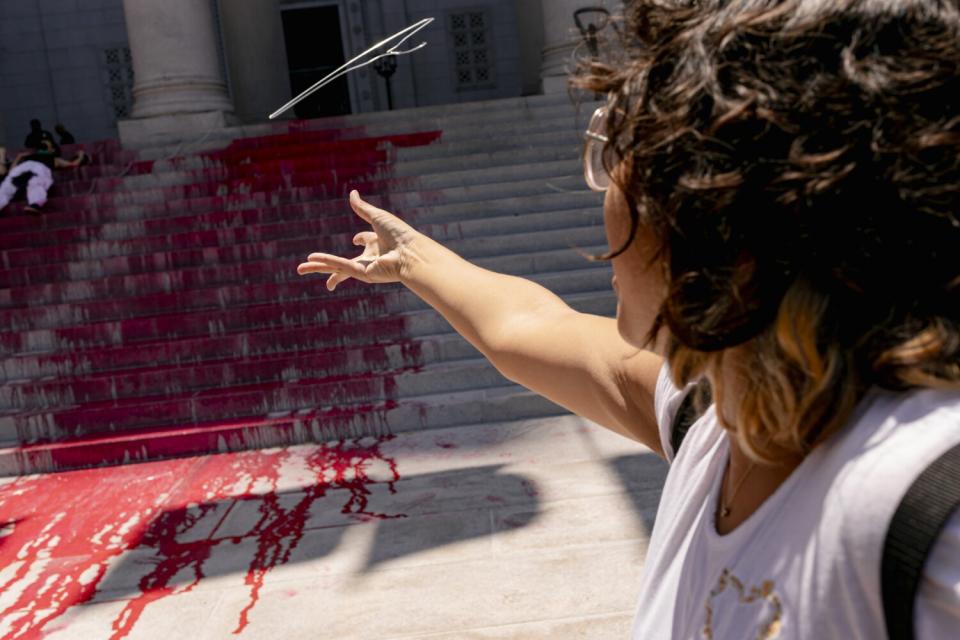 A person throws a coat hanger at steps painted red.