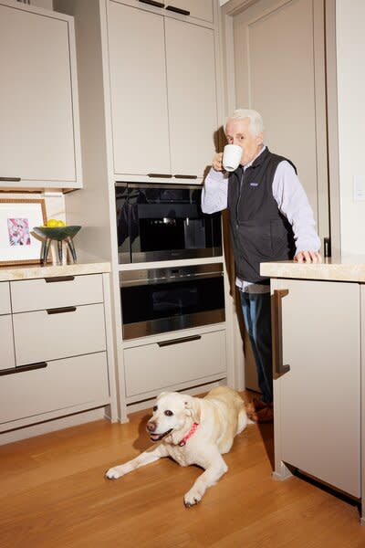 Homeowner Scott Hager enjoys a cup of coffee from his Miele espresso machine, with dog Hondo at his feet.