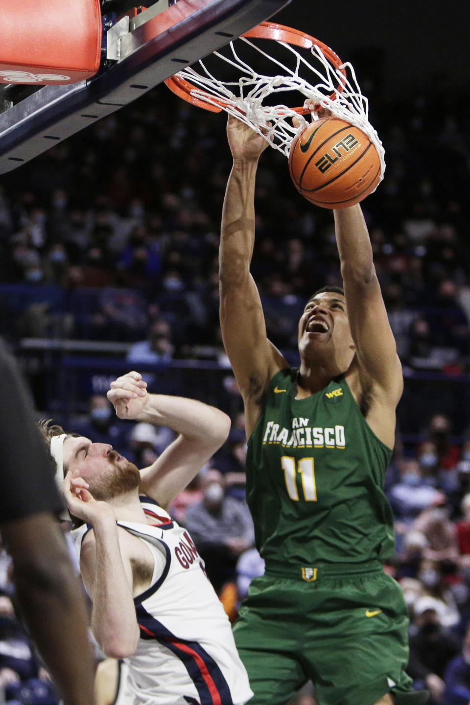 San Francisco forward Patrick Tapé, right, dunks over Gonzaga forward Drew Timme during the first half of an NCAA college basketball game Thursday, Jan. 20, 2022, in Spokane, Wash. (AP Photo/Young Kwak)