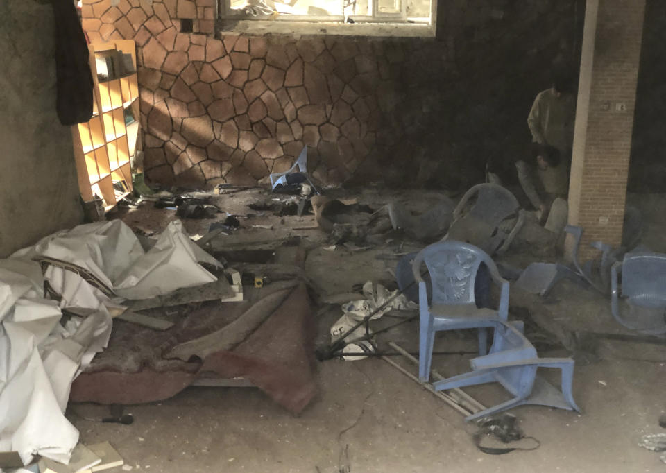 Afghan people, right, inspect the site of a bomb blast in Mazar-e-Sharif, the capital city of Balkh province, in northern Afghanistan, Saturday, March 11, 2023. A bomb exploded on Saturday during an award ceremony for journalists in the city. (AP Photo/Abdul Saboor Sirat)