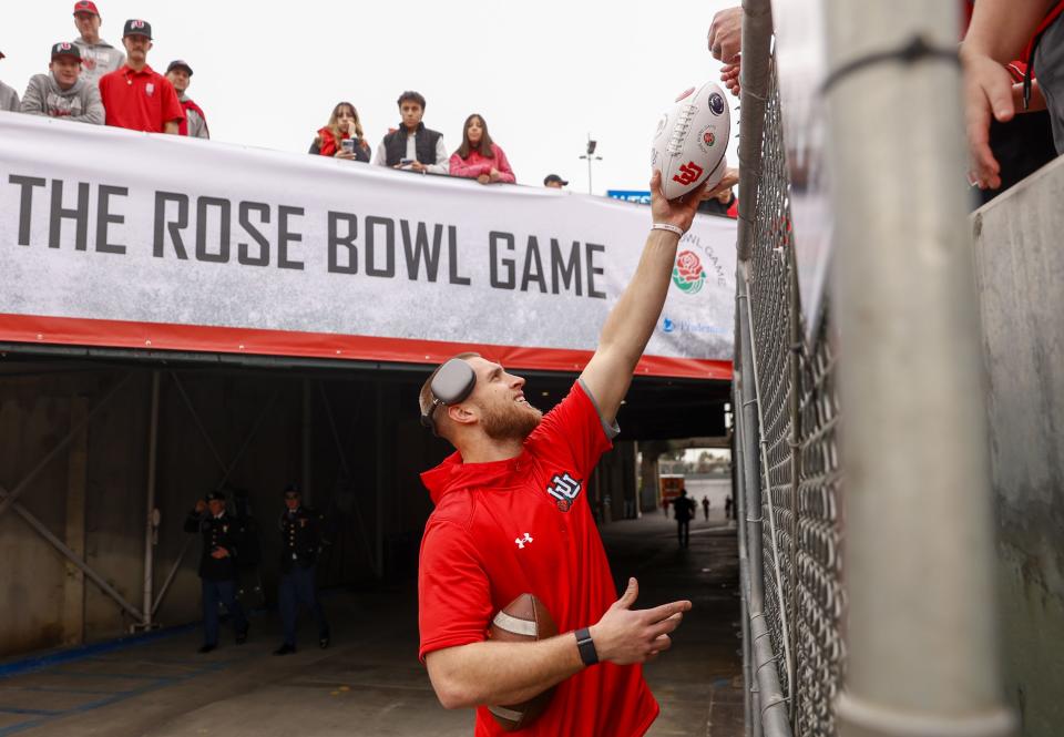 Utah Utes tight end Brant Kuithe hands a fan a signed ball.