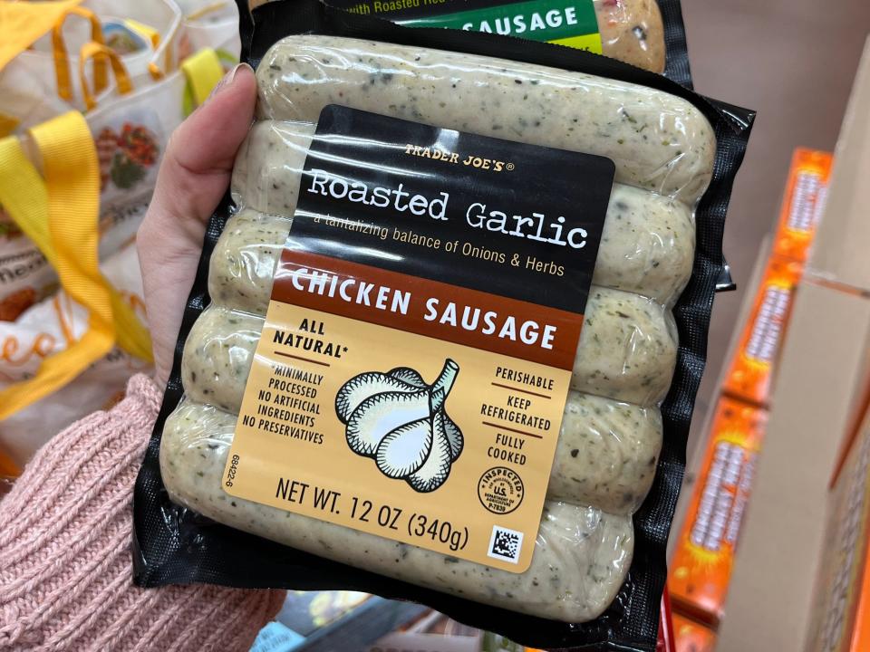 The writer holds a package of Trader Joe's toasted-garlic-chicken sausage