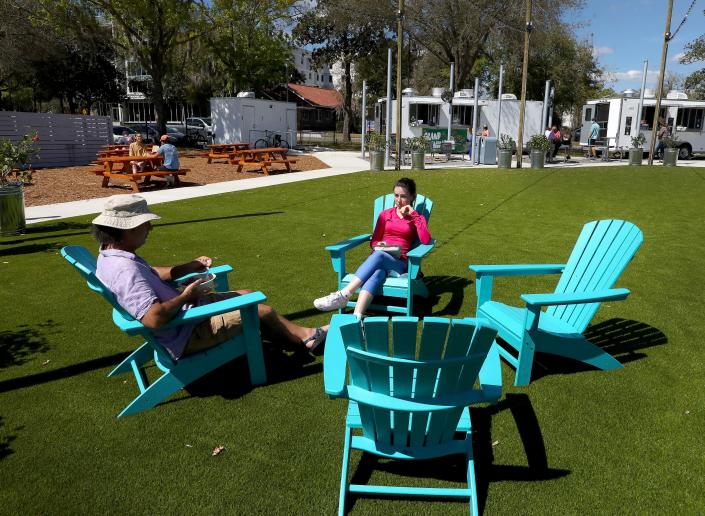 People eat in the Adirondack chairs at the Midpoint Park &amp; Eatery in Innovation Hub area of Gainesville.
