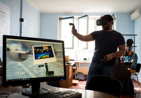 A co-founder of the New Cave Media Sergiy Polezhaka tests a simulator of virtual reality of the 2013/2014 demonstration in Ukraine, when dozens of protesters were killed in the final moments of Viktor Yanukovich's rule, in his office in Kiev, Ukraine September 11, 2018. REUTERS/Gleb Garanich