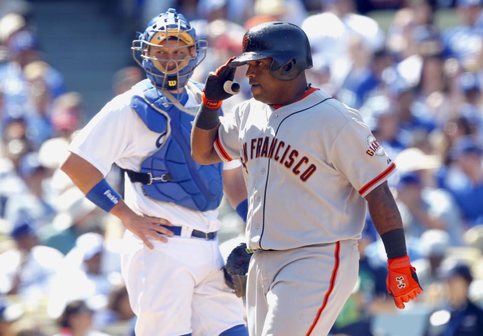 San Francisco Giants' Pablo Sandoval , right, salutes teammates after he hit a three-run home run as Los Angeles Dodgers catcher A.J. Ellis, left, looks on in the fifth inning of a baseball game on Saturday, April 5, 2014, in Los Angeles. (AP Photo/Alex Gallardo)