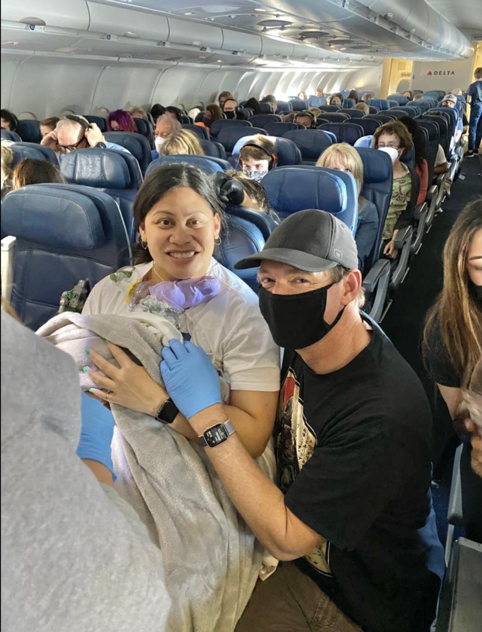 Lavinia Mounga and Dr. Dale Glenn posing after Mounga's gave birth aboard a Delta flight to Hawaii.