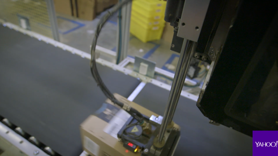 An Amazon fulfillment center SLAM machine scans item and applies a shipping label as part of the final quality-assurance check. Source: Yahoo Finance