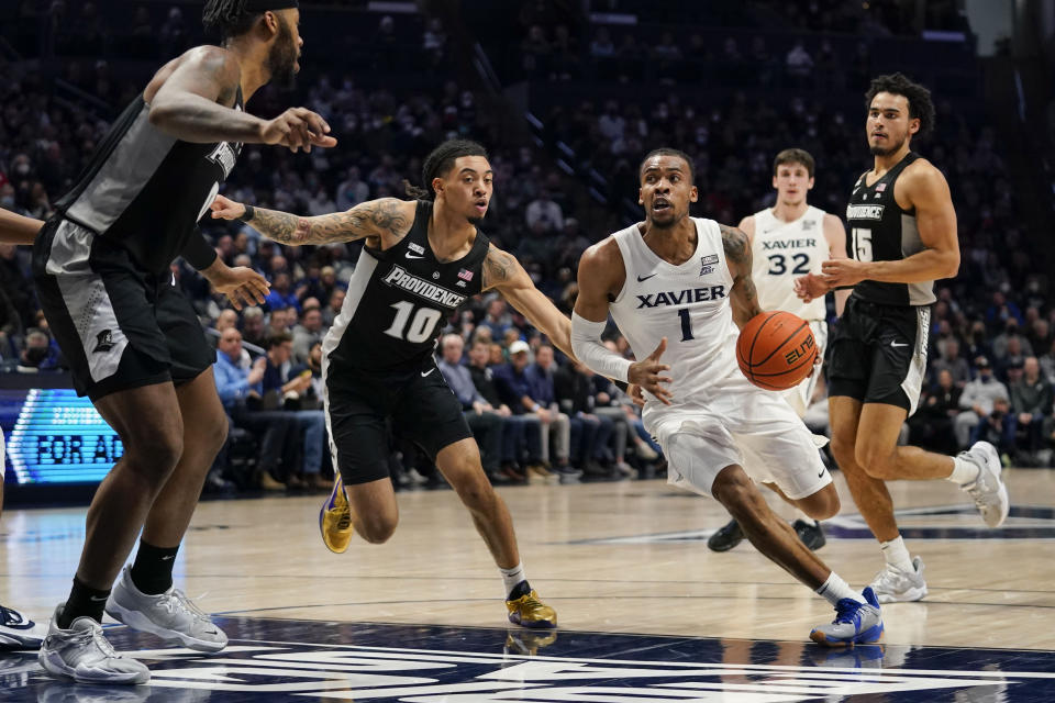 Xavier guard Paul Scruggs (1) drives past Providence's Alyn Breed (10) during the first half of an NCAA college basketball game, Wednesday, Jan. 26, 2022, in Cincinnati. (AP Photo/Jeff Dean)