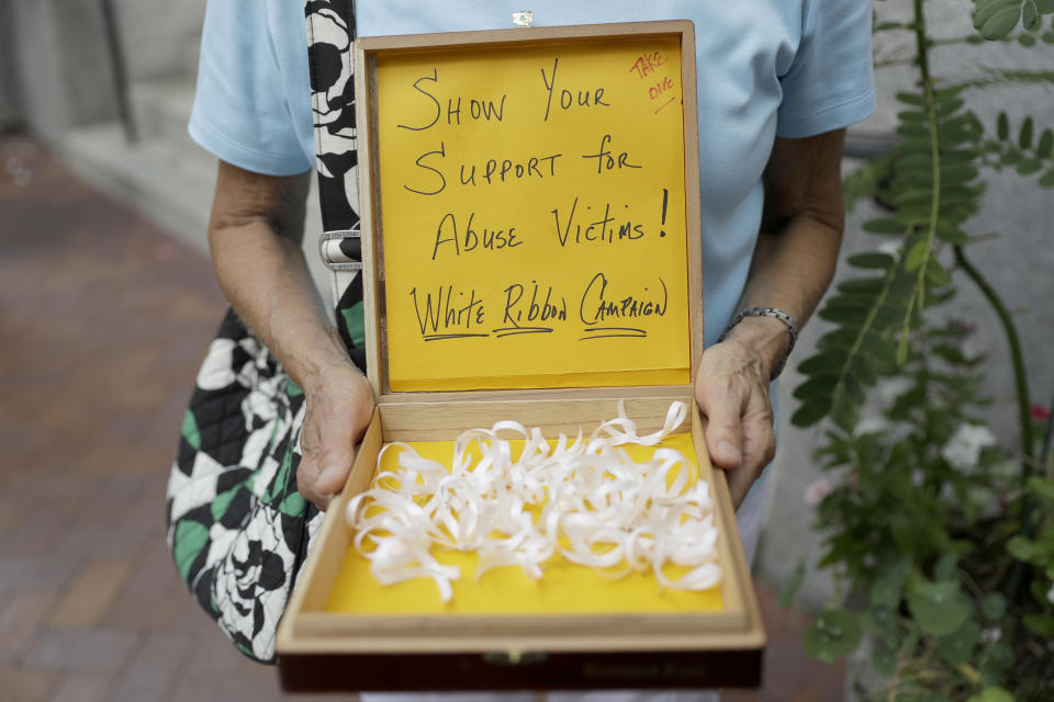 Irene Youngman holds a box of ribbons to be given away before a mass lead by Bishop Ronald Gainer, of the Harrisburg Diocese, at the Cathedral Church of Saint Patrick in Harrisburg, Pa., Friday, Aug. 17, 2018. The grand jury report released this week found rampant sexual abuse of more than 1,000 children by about 300 priests in six Pennsylvania dioceses over seven decades. It criticized Gainer for advocating to the Vatican that two abusive priests not be defrocked. (AP Photo/Matt Rourke)
