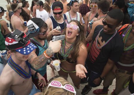 A squirt gun is used to spray alcohol into a party-goers mouth during spring break festivities in Panama City Beach, Florida March 12, 2015. REUTERS/Michael Spooneybarger
