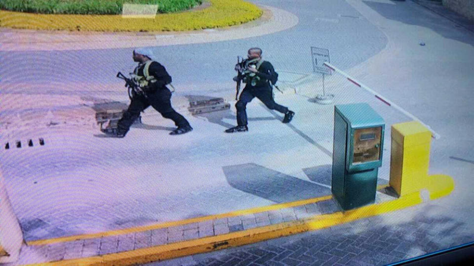 In this grab taken from security camera footage released to the local media, heavily armed attackers walk in the compound of the hotel (Picture: AP)