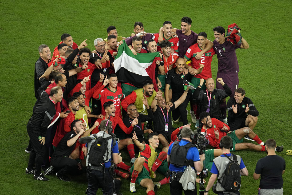 Morocco players hold the Palestinian flag while celebrating their victory over Spain during the World Cup Round of 16 last week in Qatar. (AP Photo/Abbie Parr)