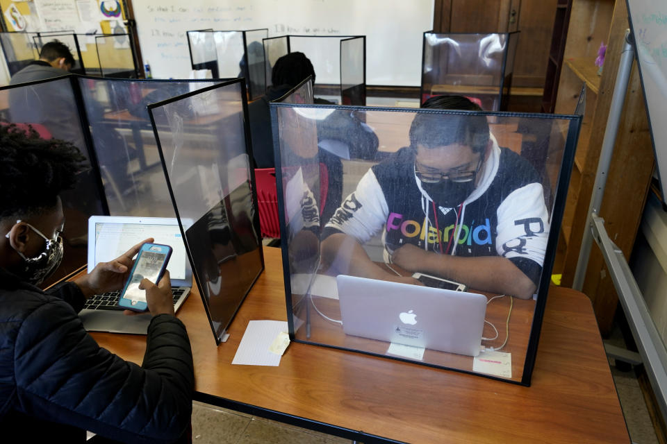 Senior Jose Solano-Hernandez, right, studies with classmates on the first day of in-person learning at Wyandotte High School in Kansas City, Kan., Wednesday, March 30, 2021. Solano-Hernandez, feared he might not graduate after a year of disrupted learning left him missing assignments in most of his classes as he struggled to learn virtually. The school, like other schools nationwide, has made extra efforts to keep kids at risk of dropping out engaged as classes went virtual due to the pandemic. (AP Photo/Charlie Riedel)