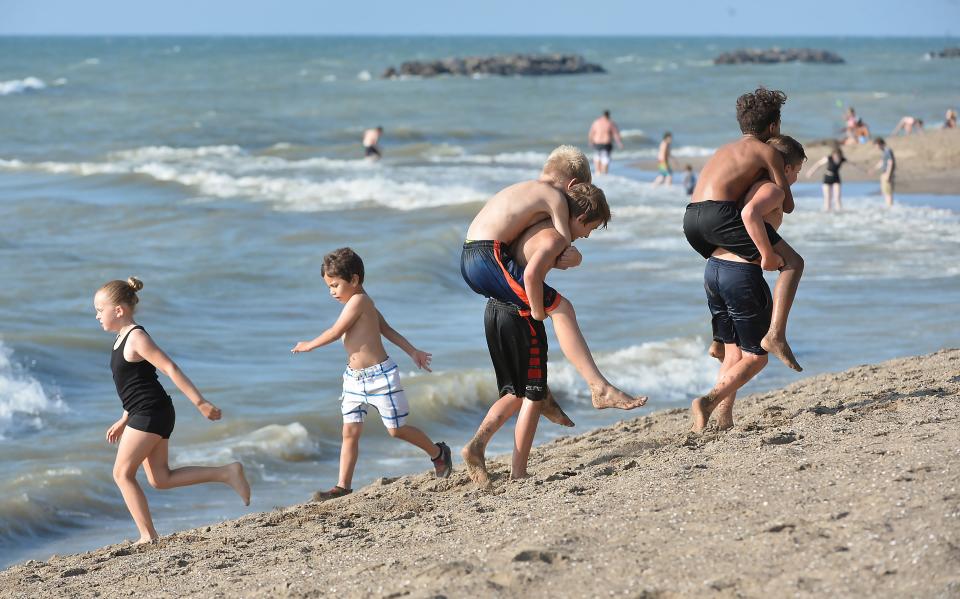 Members of the Rambler Wrestling Club take turns carrying each other up a slope at Presque Isle State Park Beach 7 in Millcreek Township on July 27, 2023.