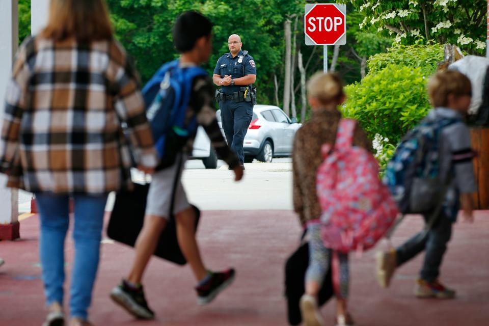 Westport police officer Fernando Goncalves monitors morning activities as students arrive at the Alice Macomber school on Gifford Road in Westport.