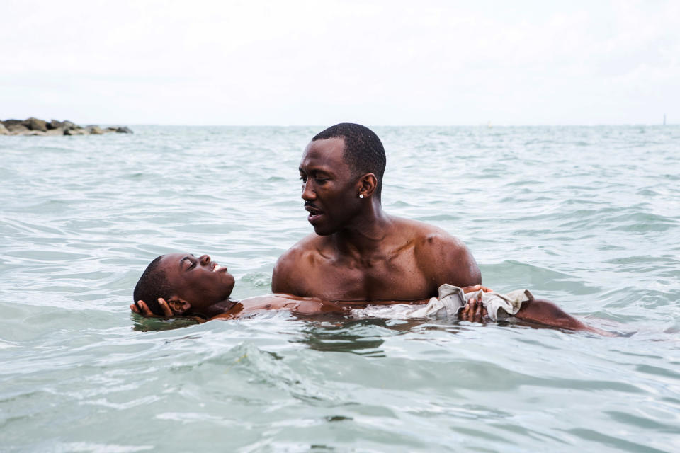 Mahershala Ali holds Alex R. Hibbert in the water