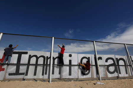 Children climb up the border fence between Ciudad Juarez and El Paso, United States, during a bi-national Mass in support of migrants in Ciudad Juarez, Mexico, February 15, 2016. REUTERS/Jose Luis Gonzalez