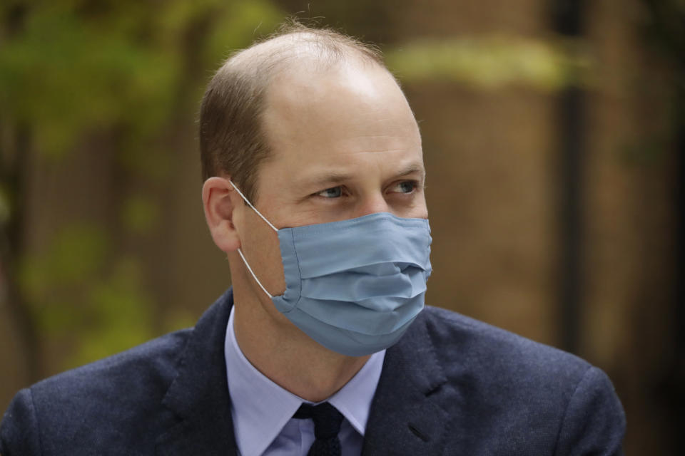 LONDON, ENGLAND - OCTOBER 20: Wearing a face covering to curb the spread of coronavirus, Prince William, Duke of Cambridge meets pharmacist Joyce Duah as he and Catherine, Duchess of Cambridge visit St. Bartholomew's Hospital in London, to mark the launch of the nationwide 'Hold Still' community photography project, on October 20th, 2020 in London, England.  The Duke and Duchess of Cambridge on Tuesday met a small number of staff from the hospital, including pharmacist and photographer Joyce Duah and the two pharmacy technician colleagues she photographed writing on their PPE as they put it on, in a photograph that was selected to be in the set of 100 images taken during the coronavirus lockdown. (Photo by Matt Dunham - WPA Pool/Getty Images)