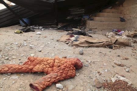 Clothing lies abandoned in front of burnt out huts in Mount Sumi, Angola, in this picture taken May 3, 2015. REUTERS/Herculano Coroado