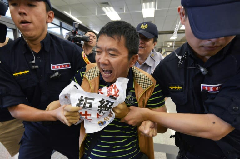 A protester from the Taiwan Solidarity Union (TSU) is dragged away by police as a top Chinese official arrives at Songshan airport near Taipei, on August 22, 2016