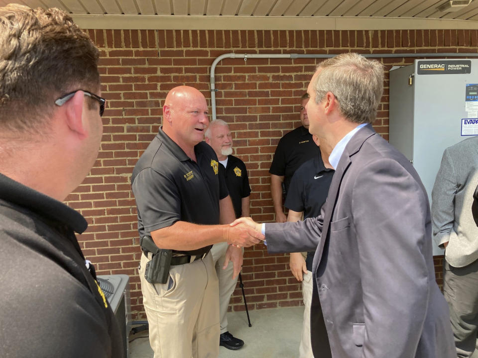 Kentucky Gov. Andy Beshear, right, greets law enforcement officers at a campaign event on Tuesday, June 6, 2023, in Frankfort, Ky. The governor touted his record on public safety issues as he seeks re-election to a second term. (AP Photo/Bruce Schreiner)