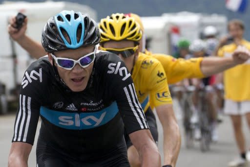 A fan runs behind overall leader's yellow jersey, British Bradley Wiggins, and second placed in the overall standings, Great Britain's Christopher Froome (L) as they ride in the seventeenth stage of the 2012 Tour de France cycling race starting in Bagneres-de-Luchon and finishing in the ski resort of Peyragudes, southern France