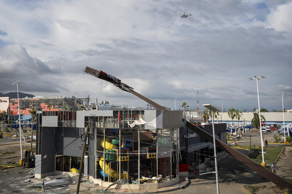 A helicopter flies over Acapulco, Mexico, in the aftermath of Hurricane Otis, Friday, Oct. 27, 2023. (AP Photo/Felix Marquez)