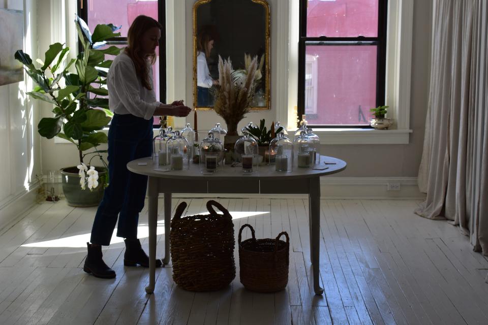 Natalie Blanton, owner and creator of Honey Water Candles, lights candles on a table in her new shop, Honey Water Candles April 11, 2022 in downtown Berlin, Md.