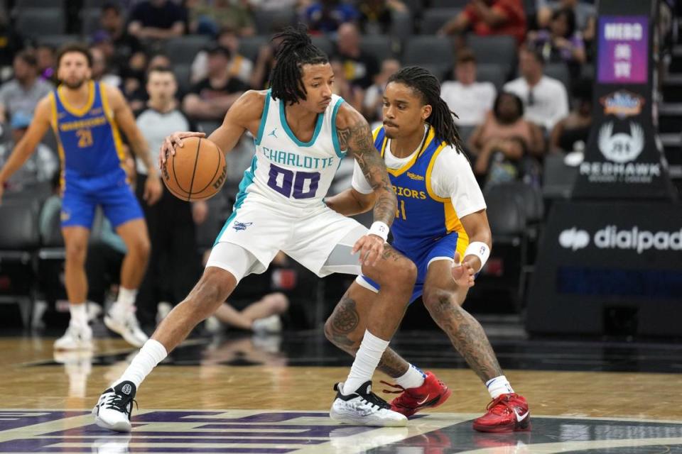 Jul 5, 2023; Sacramento, CA, USA; Charlotte Hornets guard Nick Smith Jr. (00) dribbles against Golden State Warriors guard Yuri Collins (right) during the second quarter at Golden 1 Center. Mandatory Credit: Darren Yamashita-USA TODAY Sports