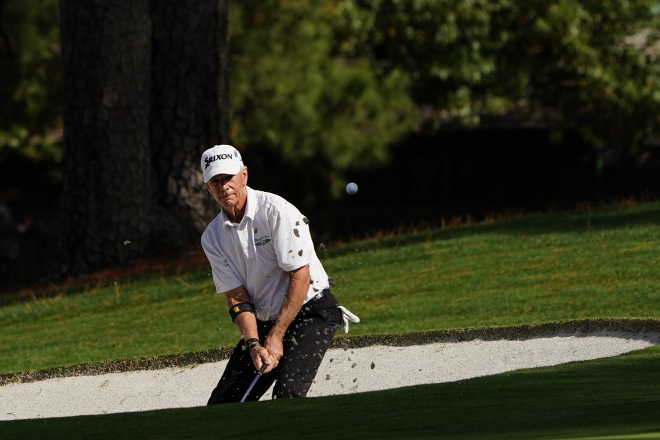 Larry Mize chips out of a bunker on the seventh hole during the first round of the Masters golf tournament Thursday, Nov. 12, 2020, in Augusta, Ga. (AP Photo/Matt Slocum)