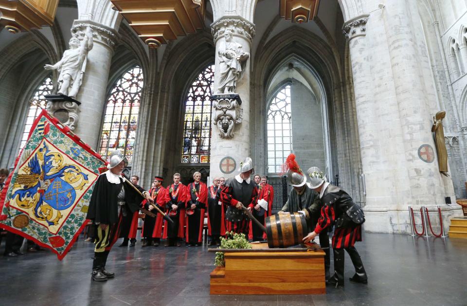 Members of the Knighthood of the Brewers' Mash staff carry a barrel of beer inside the Sint-Gudule Cathedral in Brussels