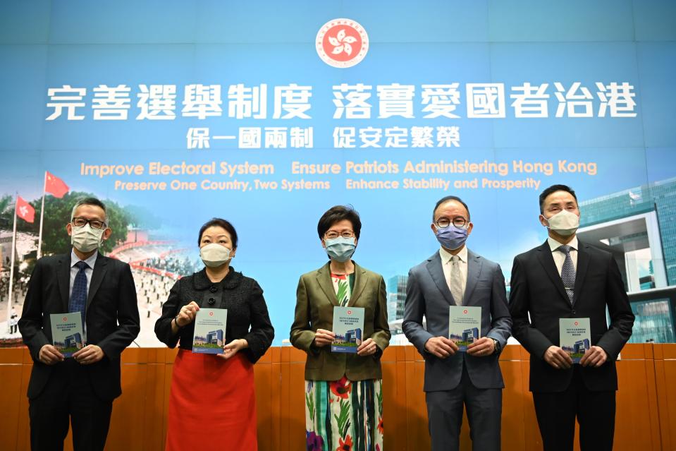 From Left to Right Ms Llewellyn Mui, Acting Officer(Special Duties), Ms Teresa Cheng, Secretary for Justice, Mrs Carrie Lam, Chief Executive of Hong Kong, Mr Eric Tsang, Secretary for constitution and mainland affairs, Mr Roy Tang, permanent secretary for Constitutional and Mainland affairs hols up booklet during a press conference on 'Improving Electoral System' in Hong Kong, China, on April 13, 2021. The government is formally proposing to make it a crime for people to urge others to cast blank or spoiled ballots, or not vote at all, as it unveiled a host of bills to amend local laws in line with the sweeping electoral reforms initiated by Beijing last month. It would also be a crime to obstruct or prevent people from casting a ballot. Both offences would be punishable by up to three years in prison, The paper also laid out detailed arrangements for how the expanded 1,500-member Election Committee will be selected in an election to be held on September 19, The powerful body will nominate all legislators and select 40 of them through block-voting, That means each member selects 40 members, and the 40 individuals with the most votes at the end will win the seats, All members will be required to swear allegiance to the SAR, and vow to uphold the Basic Law, The Election Committee would also keep its current role of choosing the chief executive, with the next election set for March 27, Authorities also unveiled the 10 new geographical constituencies that will return 20 of the 90 new legislators to be chosen on December 19. The paper also laid out detailed arrangements for how the expanded 1,500-member Election Committee will be selected in an election to be held on September 19. (Photo by Vernon Yuen/NurPhoto via Getty Images)